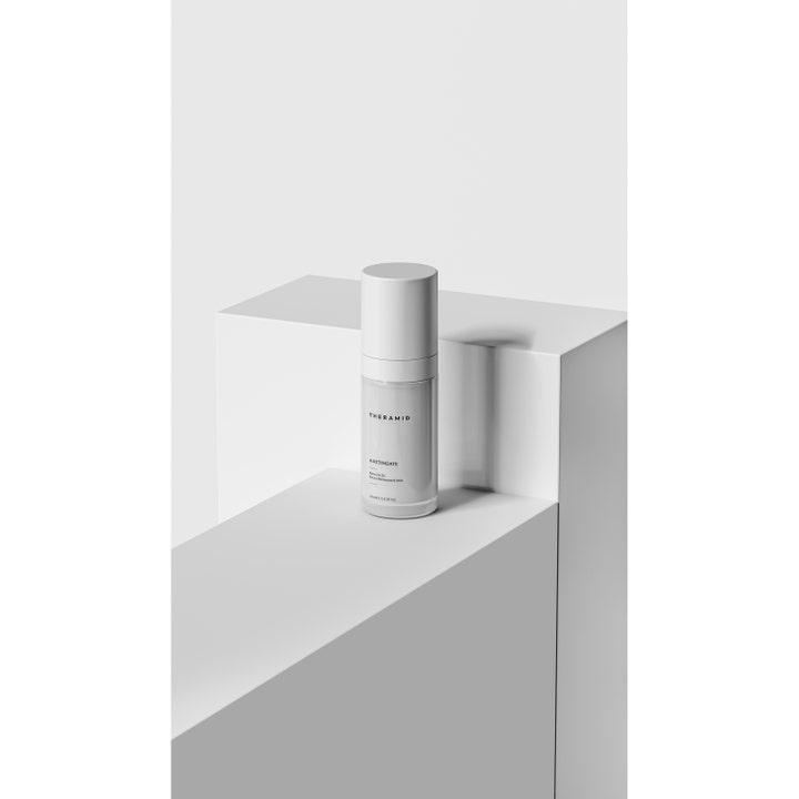 Niche Beauty Lab Theramid A-Retinyl Retinoate 30 ml uudistava seerumi valkoisessa pumppupullossa modernilla alustalla.