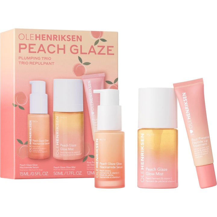 Ole Henriksen Peach Glaze Plumping Trio heleyttävä ihonhoitosetti sisältää persikanvärisiä tuotteita valkoisilla korkeilla.