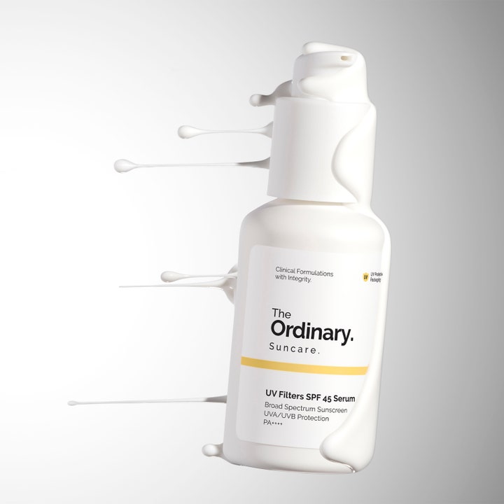 The Ordinary UV Filters SPF 45 Serum 60 ml suojaava aurinkosuojaseerumi valkoisessa pumppupullossa ja voidemaisia roiskeita.