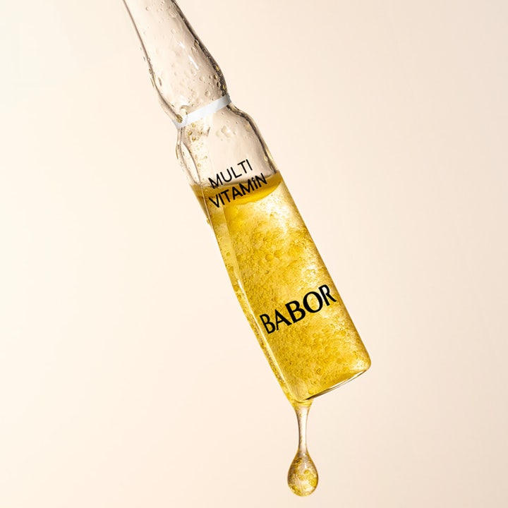 Babor Ampoule Multi Vitamin 14 ml kirkastava vitamiiniseerumi lasisessa ampullissa, josta putoaa keltainen pisara.