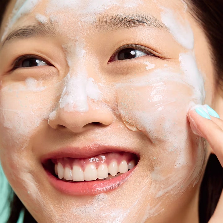 Dr.Jart+ Pore-remedy Renewing Foam Cleanser 150 ml syväpuhdistava vaahto ja vihreitä rakeita mallin kasvoilla.