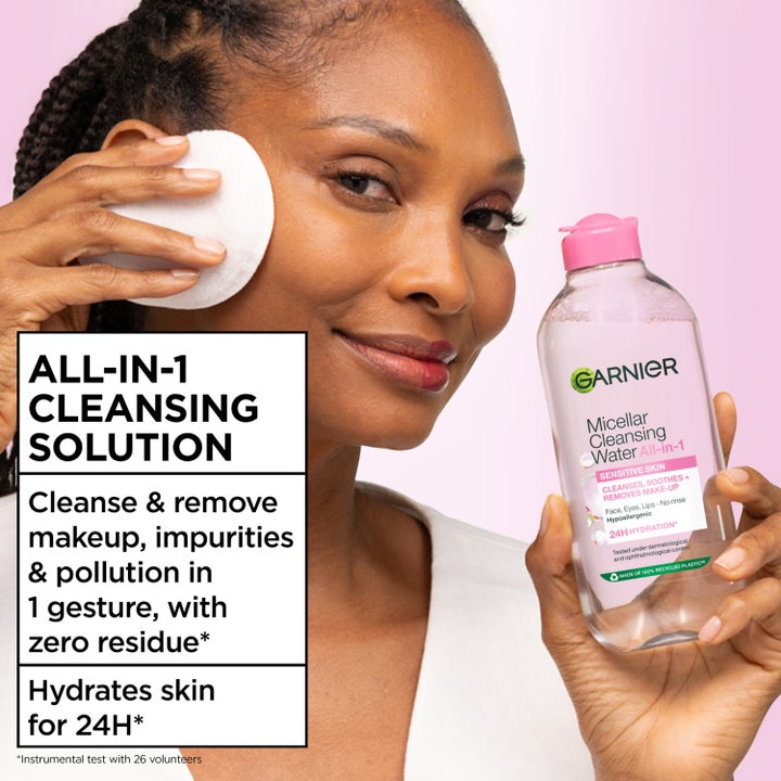 Garnier Micellar Cleansing Water 700 ml puhdistusvesi poistaa meikin. Hymyilevä nainen puhdistaa kasvot kestovanulapulla.