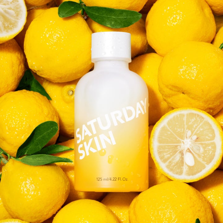 Saturday Skin Yuzu Vitamin C Brightening Toner 125 ml ihoa kirkastava kasvovesi keltaisessa pullossa yuzujen ympäröimänä