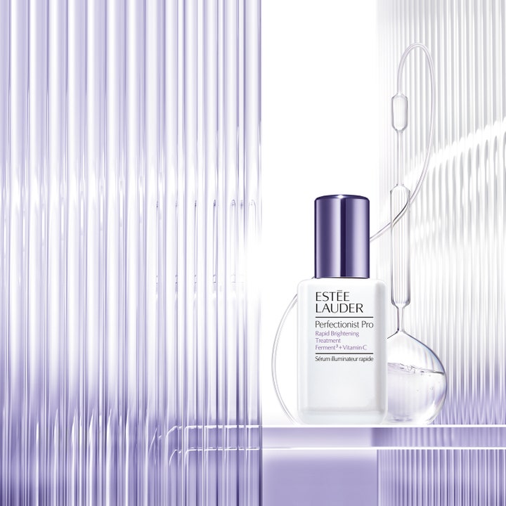Estée Lauder Perfectionist Pro Rapid Brightening Treatment 50 ml kirkastava C-vitamiiniseerumi laboratoriolasien edessä.