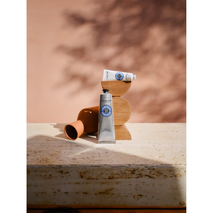 L'Occitane en Provence Shea Butter Hand Cream 30 ml käsivoide puisella jalustalla lämpimässä auringonvalossa