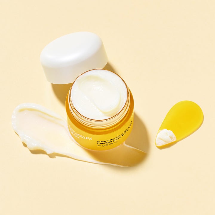 Saturday Skin Yuzu Vitamin C Lip Mask 25 g kirkastava huulinaamio avatussa keltaisessa purkissa valkoisella tekstuurilla