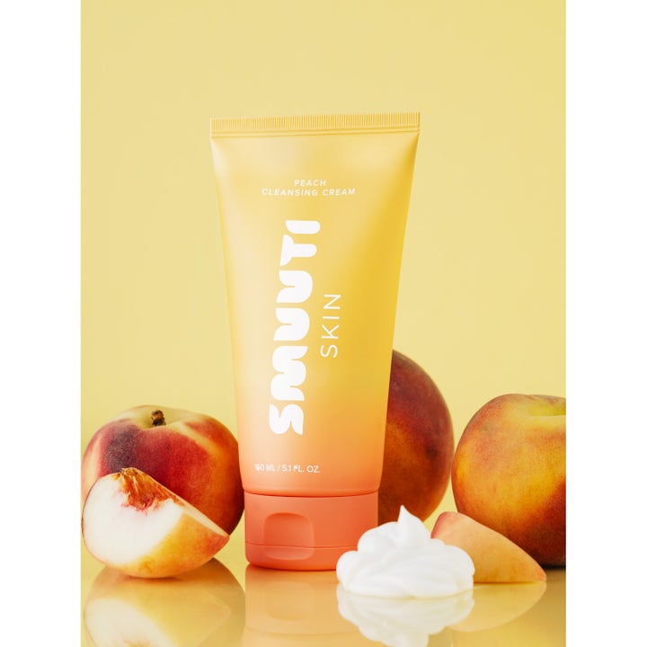 Smuuti Skin Peach Cleansing Cream 150 ml puhdistusvoide keltaisessa tuubissa persikoiden ja valkoisen voiteen kera.