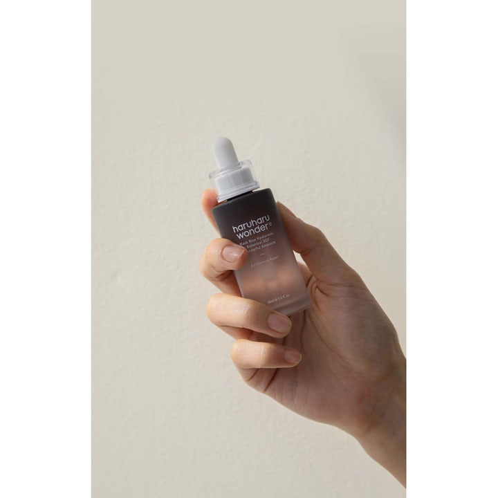 Haruharu Wonder Black Rice Hyaluronic 2GF Ampoule 30 ml seerumi tummassa lasipullossa kädessä pideltynä.