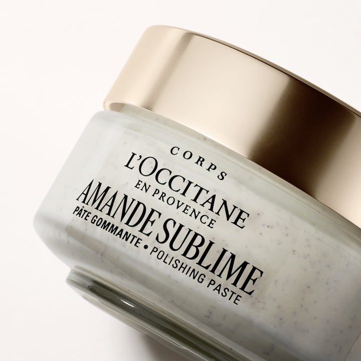 L'Occitane en Provence Almond Polishing Paste 200 ml silottava vartalokuorinta lasipurkissa, jossa on kultainen kansi.