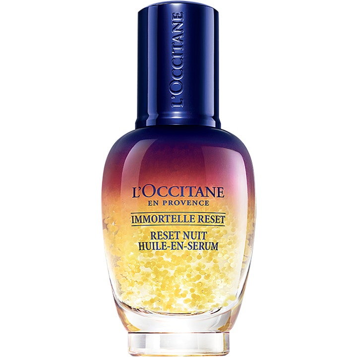L’Occitane Immortelle Overnight Reset Serum uudistava yöseerumi liukuvärjätyssä pullossa keltaisilla öljyhelmillä.