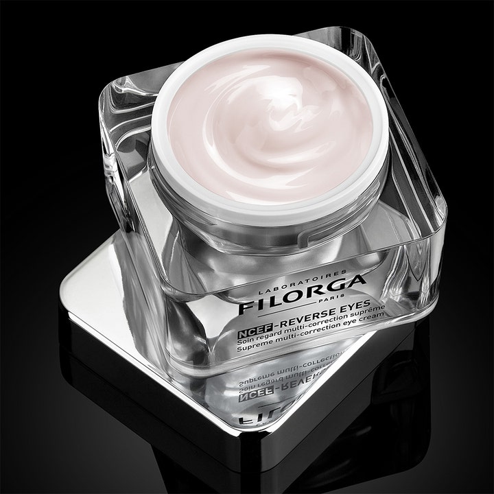 Filorga NCEF-Reverse Eyes 15 ml silmänympärysvoide läpinäkyvässä purkissa, josta näkyy vaaleanpunainen koostumus.