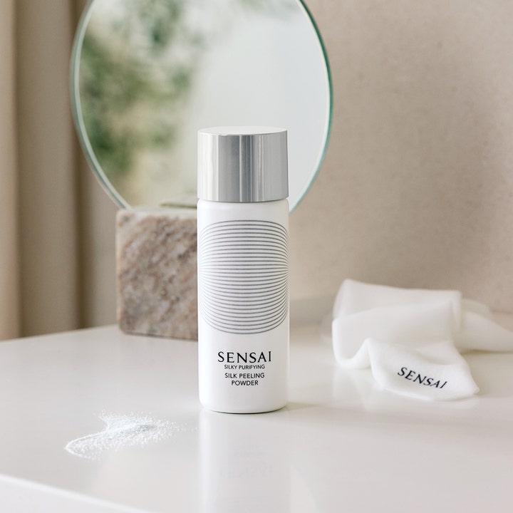 Sensai Silky Purifying Silk Peeling Powder 40 g kirkastava kuorinta valkoisessa pullossa ja hienoa jauhetta.