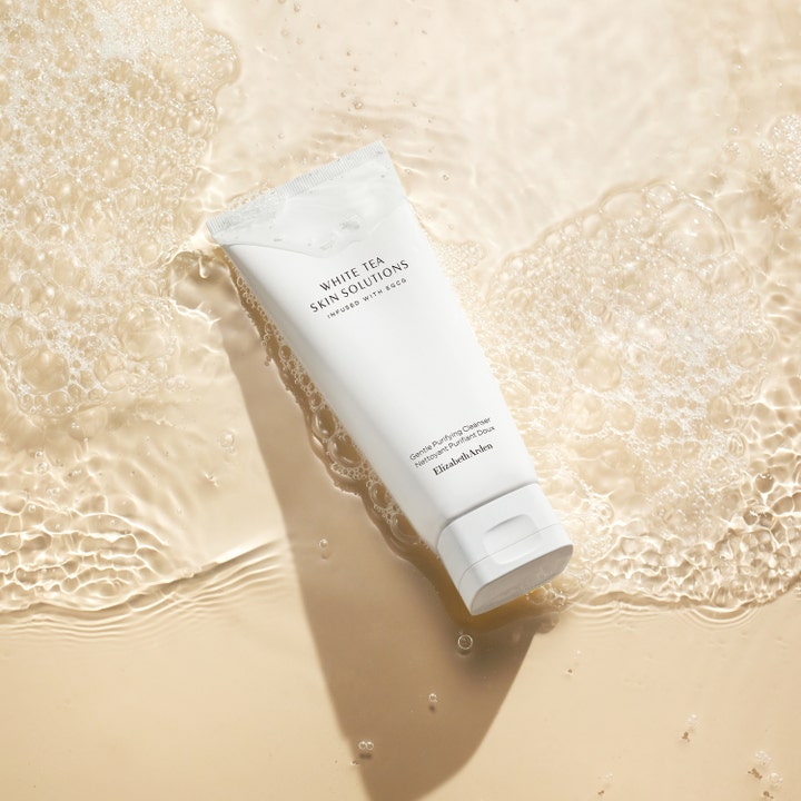 Elizabeth Arden White Tea Skin Purifying Cleanser 125 ml puhdistava geeli valkoisessa tuubissa veden ja vaahdon ympäröimänä