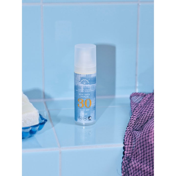 Rudolph Care Sun Face Serum 30 ml suojaava aurinkoseerumi sinisessä pullossa vaaleansinistä laattaa vasten