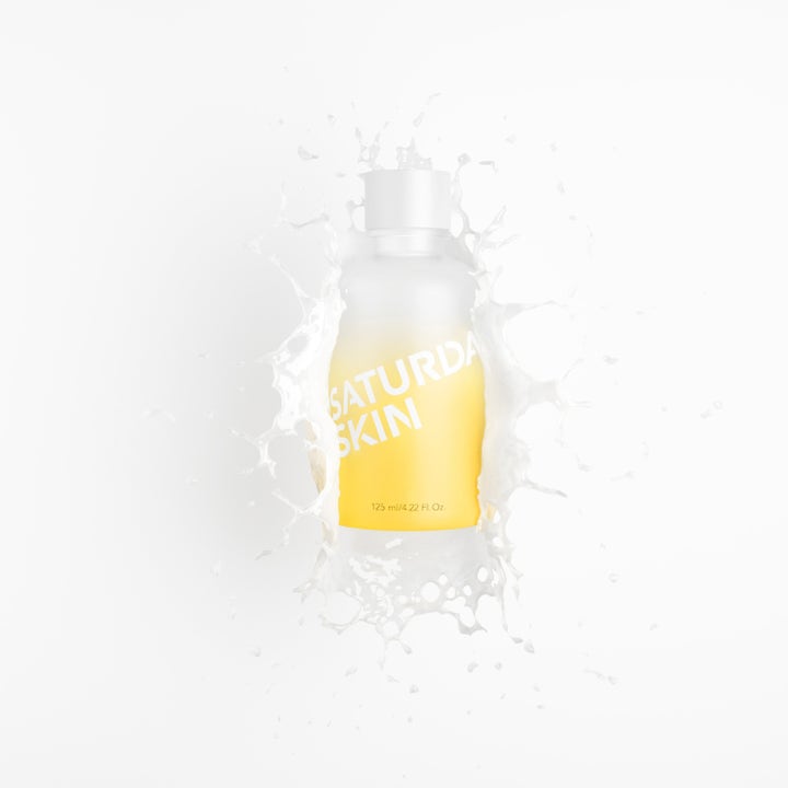 Saturday Skin Yuzu Vitamin C Brightening Toner 125 ml kirkastava kasvovesi huurteisessa pullossa valkoisen roiskeen keskellä.