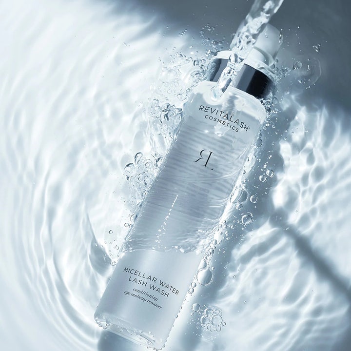 RevitaLash Micellar Water Lash Wash 100 ml puhdistava misellivesi kirkkaassa pullossa vesiroiskeiden keskellä.