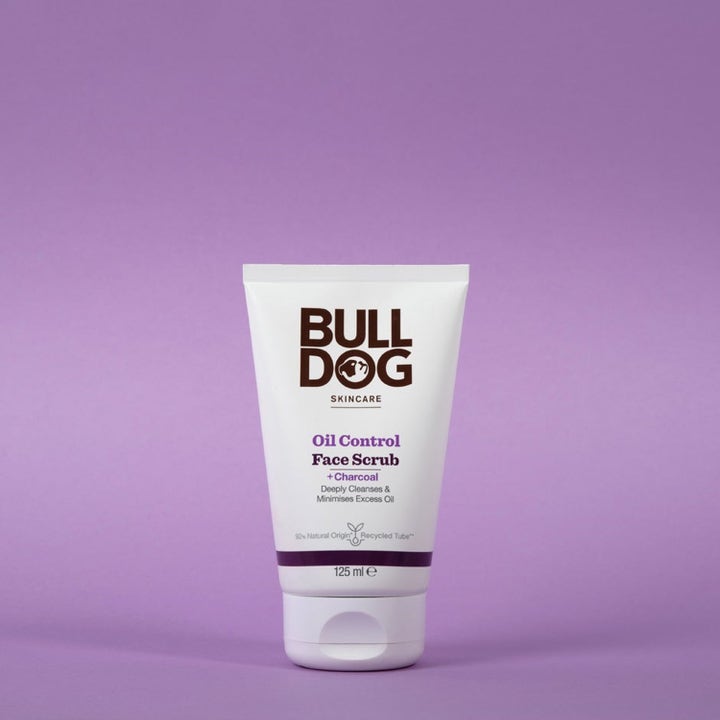 Bulldog Oil Control Face Scrub 125 ml hiiltä sisältävä syväpuhdistava kasvokuorinta valkoisessa tuubissa liilalla taustalla