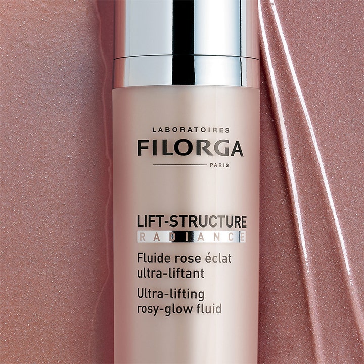 Filorga Lift-Structure Radiance 50 ml kiinteyttävä päivävoide vaaleanpunaisessa pullossa ja hohtava voidekoostumus