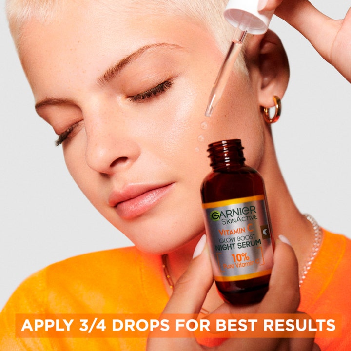 Garnier SkinActive Vitamin C 10% Night Serum 30 ml heleyttävä yöseerumi jota malli levittää kasvoilleen pipetillä.