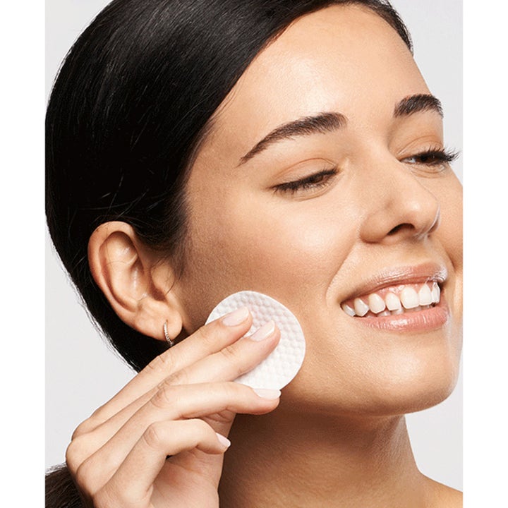 Exuviance Daily Resurfacing Peel 58 ml uudistava kuorinta nainen levittää tuotetta kasvoilleen valkoisella lapulla