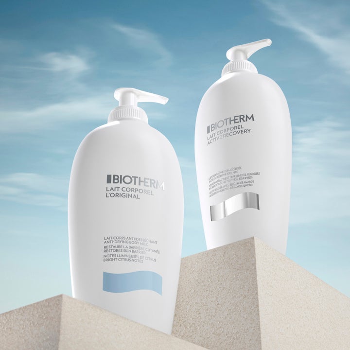 Biotherm Lait Corporel Active Recovery 400 ml korjaava vartalovoide valkoisessa pullossa kivisellä jalustalla taivasta vasten.
