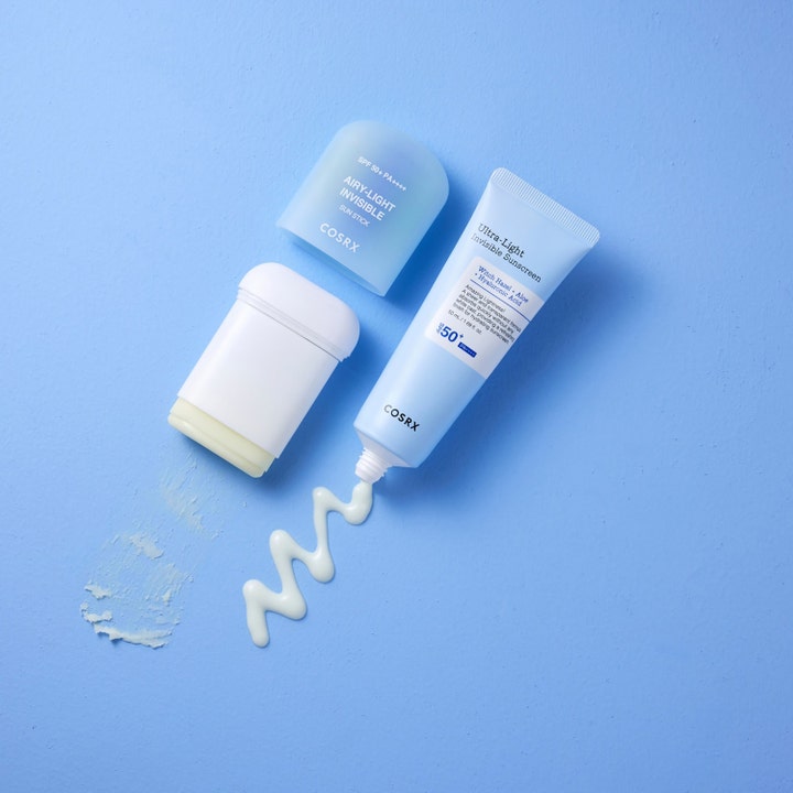 COSRX Airy-Light Invisible Sun Stick 19 g aurinkosuoja ja SPF 50 aurinkovoide kasvoille sekä vaalea voidekoostumus.