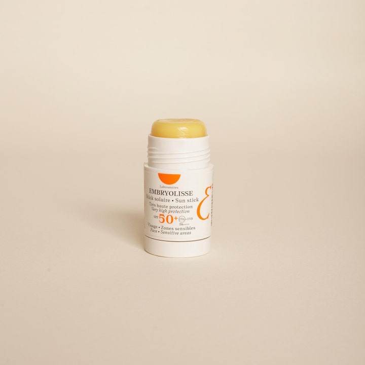 Embryolisse Sun Stick SPF50+ 15 g suojaava aurinkosuojapuikko valkoisessa hylsyssä jossa on kellertävä kiinteä voide