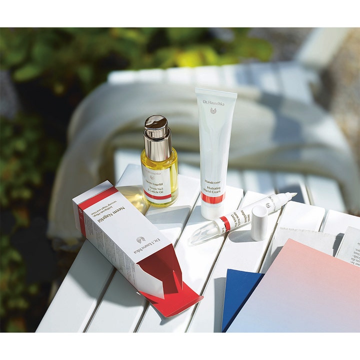 Dr. Hauschka Hand Cream 50 ml pehmentävä käsivoide valkoisella puupöydällä aurinkoisessa ulkomiljöössä.