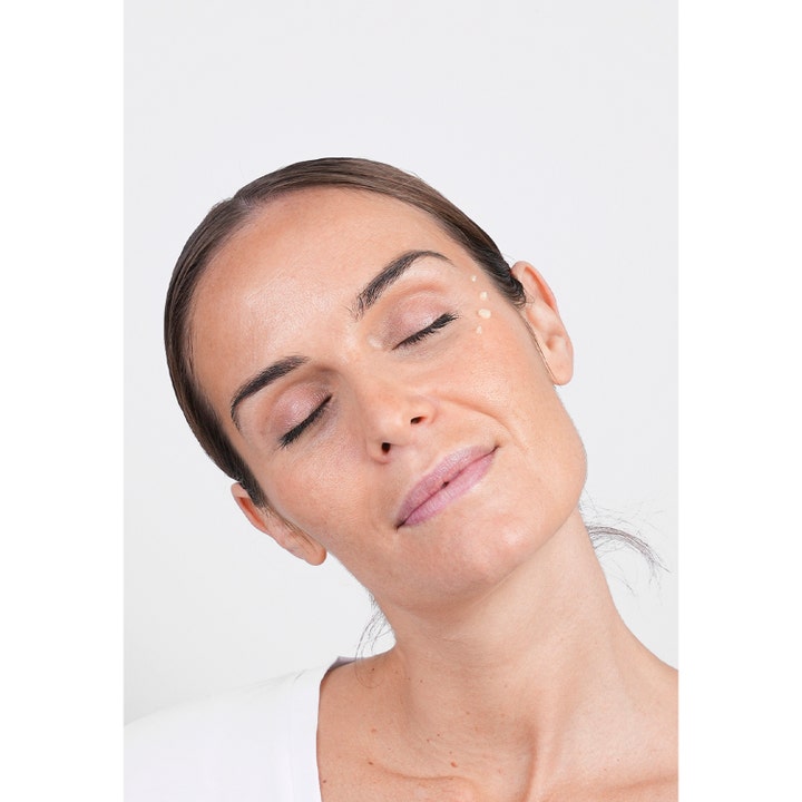 Niche Beauty Lab Transparent Lab De-Bloat Soothing Eye Serum 15 ml rauhoittava seerumi pisteinä naisen silmänurkassa.