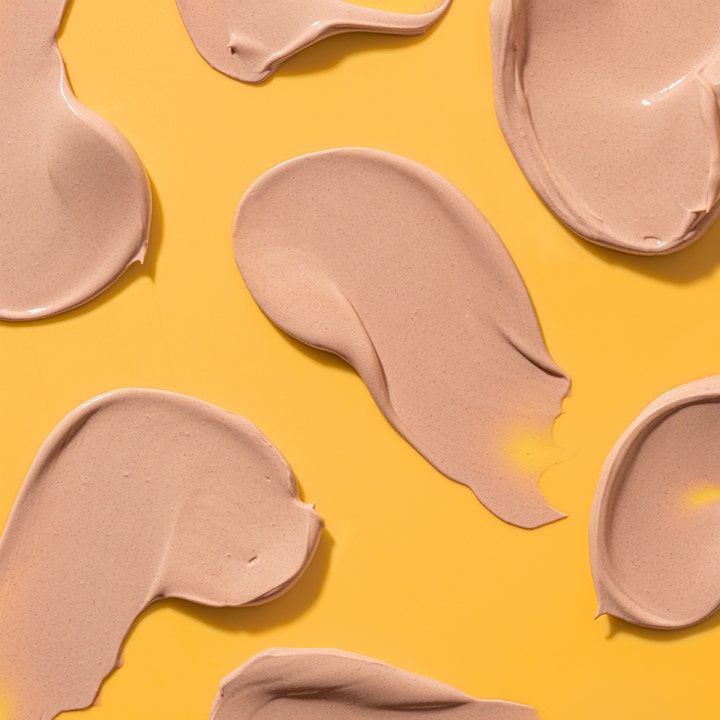 Bondi Sands SPF50+ Hydrating Tinted Face Lotion 75 ml kosteuttava aurinkovoide beigenä voidetekstuurina keltaisella pohjalla.