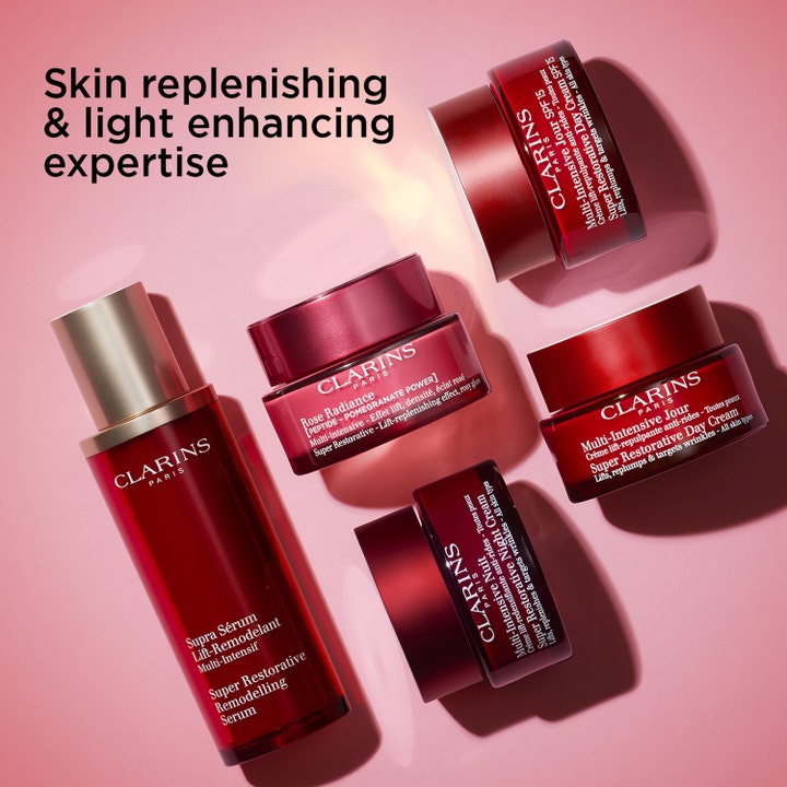 Clarins Rose Radiance Super Restorative 50 ml heleyttävä päivävoide punaisissa purkeissa vaaleanpunaisella pohjalla