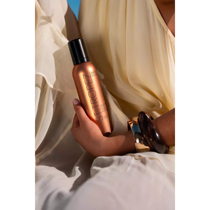 St.Tropez Instant Glow Body Bronzing Mousse 200 ml itseruskettava mousse kuparinvärisessä pullossa kädessä pidettynä.