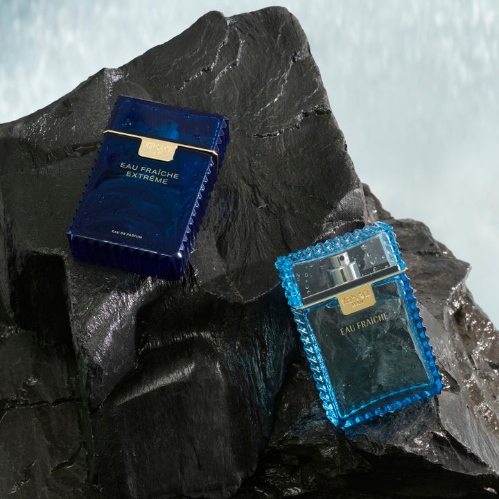 Versace Eau Fraiche Extreme 250 ml suihkugeeli raikkaissa sinisissä pulloissa märän ja tumman kallion päällä.