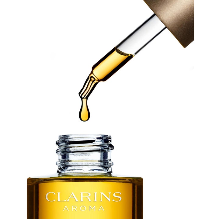 Clarins Face Treatment Oil Santal 30 ml ansiktsolja jonka pipetti tiputtaa kultaista öljyä lasipulloon.