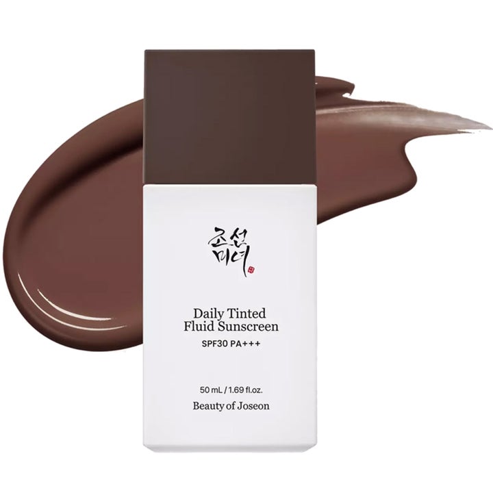 Beauty of Joseon Daily Tinted Fluid Sunscreen 50 ml suojakerroin SPF30 tummanruskean voidepyyhkäisyn edessä.