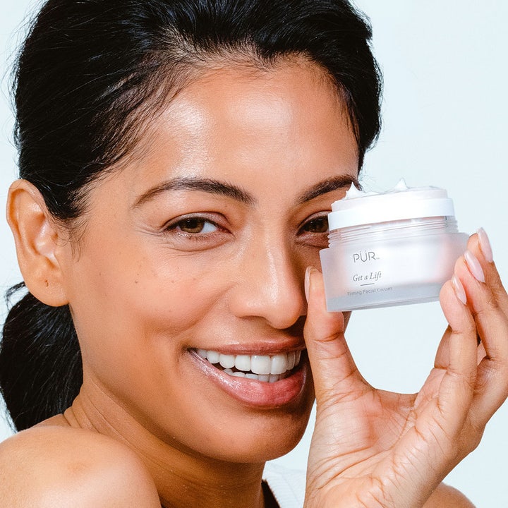PÜR Get A Lift Cream 50 ml kiinteyttävä kasvovoide nainen pitelee avattua himmeää lasipurkkia kasvojensa vieressä