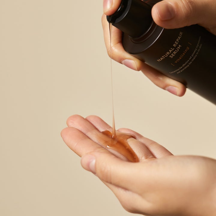 Hyggee Natural Repair Serum 120 ml elvyttävä seerumi jonka ruskea ginseng-koostumus valuu kämmenelle.