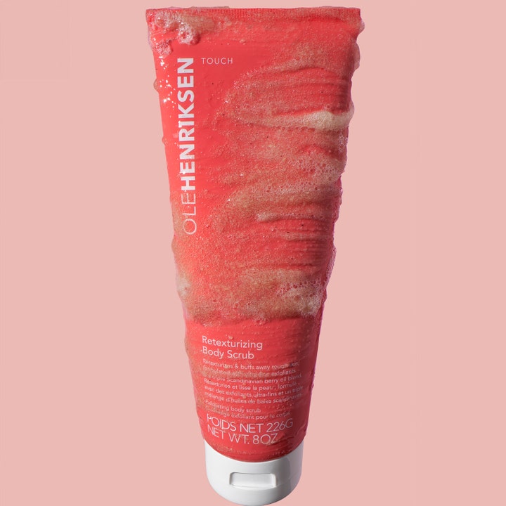 Ole Henriksen Touch Retexturizing Body Scrub 240 g silottava vartalokuorinta pinkissä tuubissa, jossa on rakeista tekstuuria.