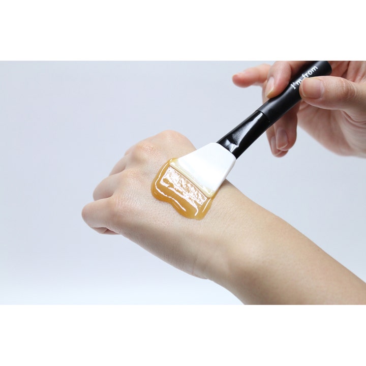 I'm From Honey Mask 120 ml ravitseva kasvonaamio levitettynä kädelle paksuna hunajaisena geelinä siveltimellä.