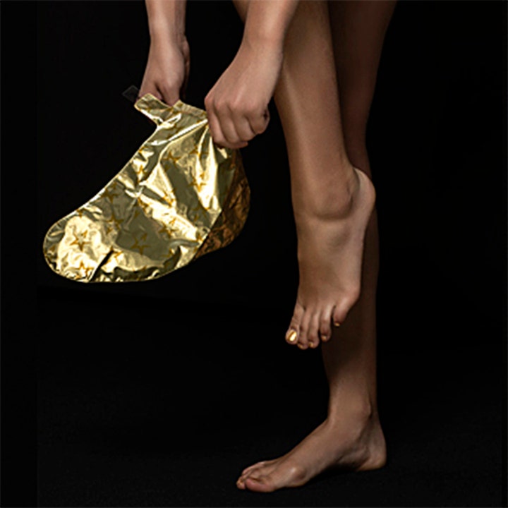 Starskin The Gold Mask Foot 16 g pehmentävä jalkanaamio on kultainen foliosukka, jota henkilö pukee jalkaansa.