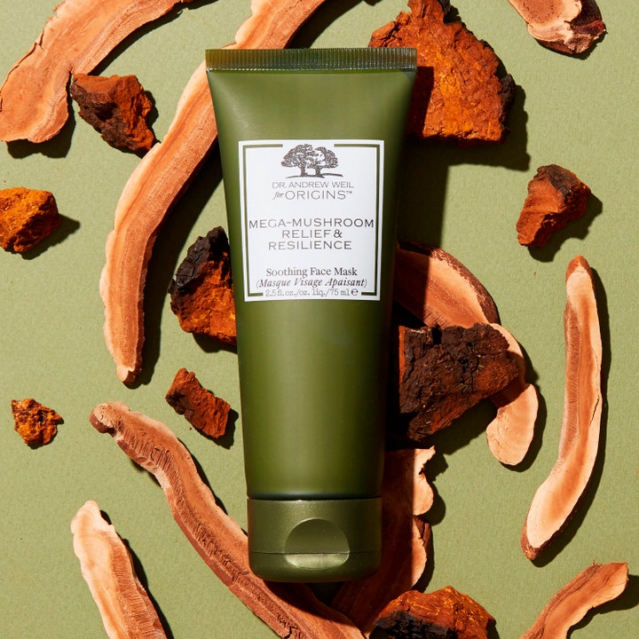 Origins Dr. Weil Mega-Mushroom 75 ml rauhoittava kasvonaamio vihreässä tuubissa lakkakäävän palojen ympäröimänä.