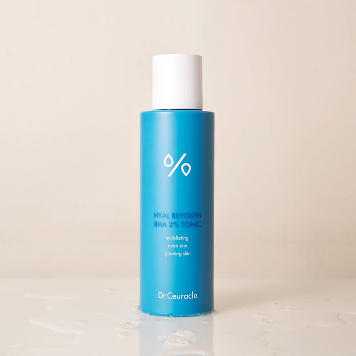Dr. Ceuracle Hyal Reyouth BHA 2% Tonic 100 ml kuoriva kasvovesi sinisessä pullossa vesiroiskeiden ympäröimänä.