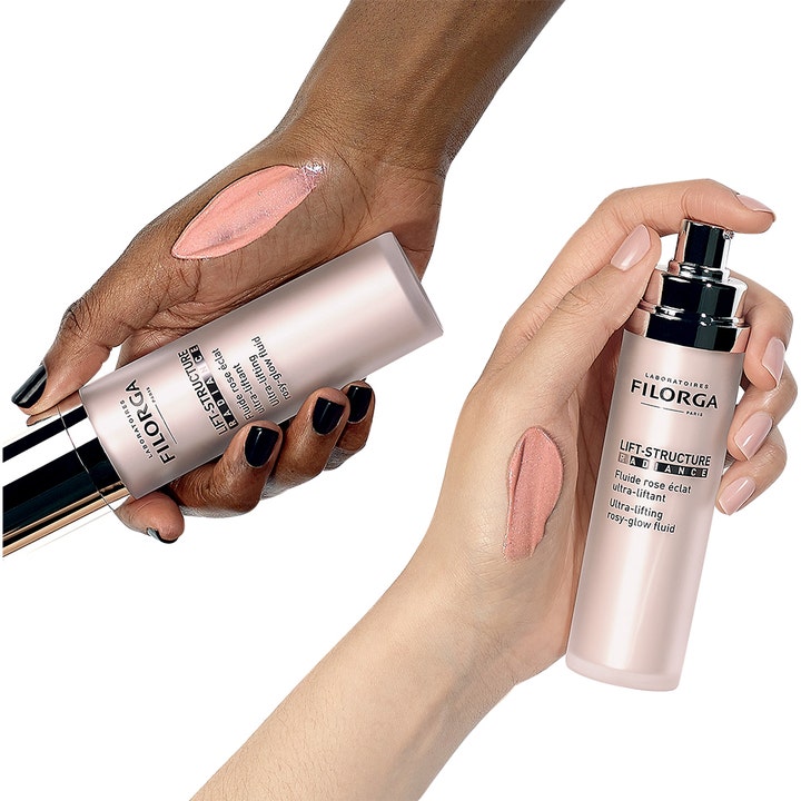 Filorga Lift-Structure Radiance 50 ml heleyttävä päivävoide ja vaaleanpunainen koostumus iholla.