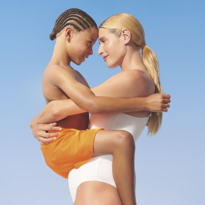 Garnier Ambre Solaire Sensitive Advanced Kids 270 ml aurinkorasva suojaa ihoa nainen syleilee lasta taivasta vasten