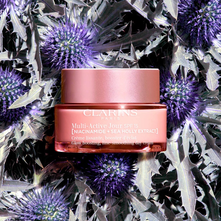 Clarins Multi-Active Jour 50 ml heleyttävä päivävoide niasiiniamidilla pinkissä purkissa piikkiputkien päällä.