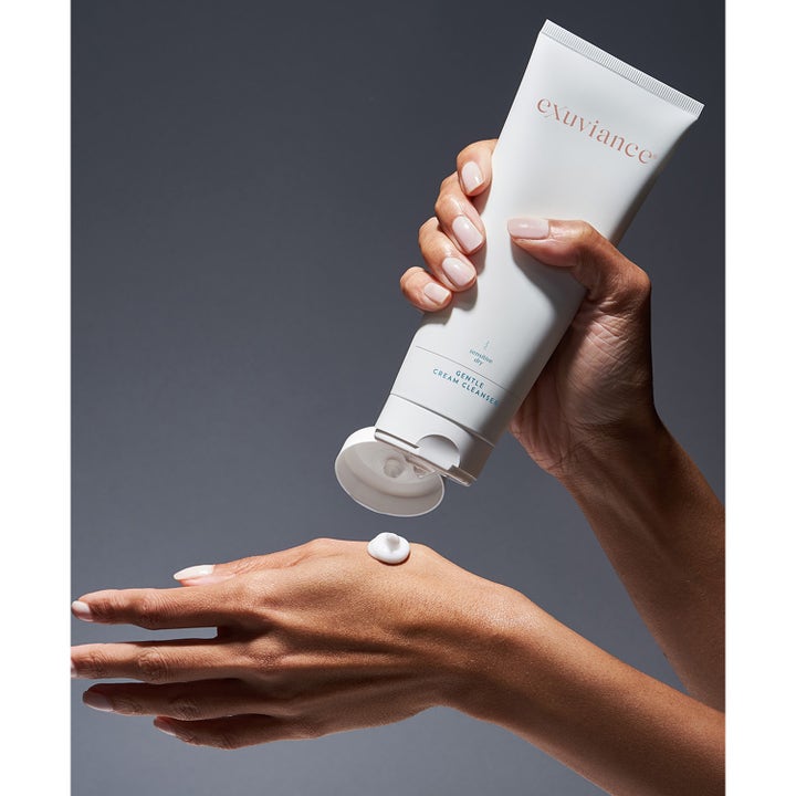Exuviance Gentle Cream Cleanser 212 ml puhdistusvoide annostellaan kädelle valkoisesta tuubista.