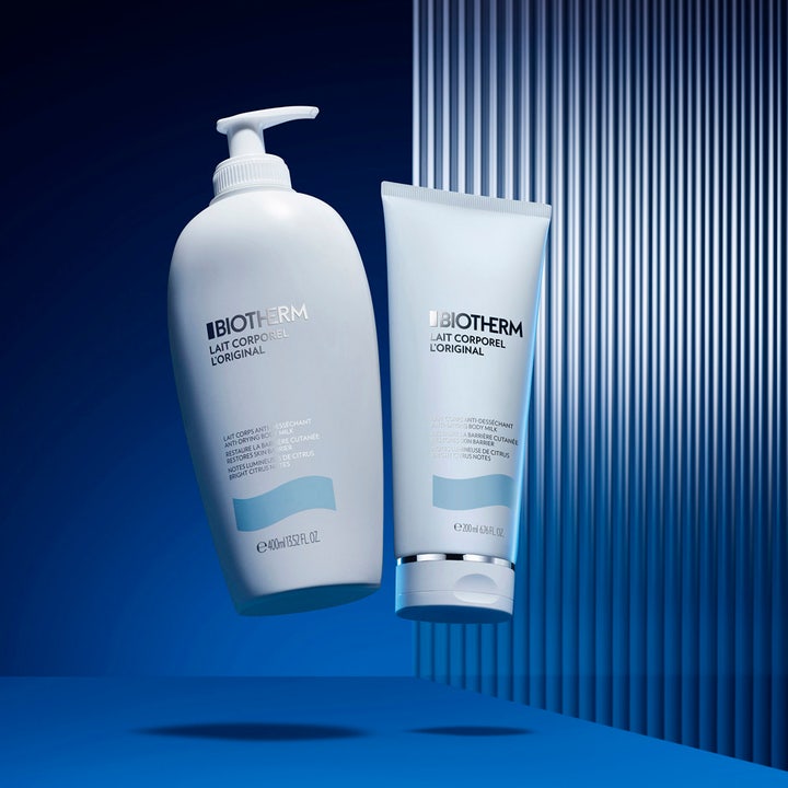 Biotherm Lait Corporel 200 ml kosteuttava vartalovoide valkoisessa tuubissa ja pumppupullossa sinisellä taustalla.