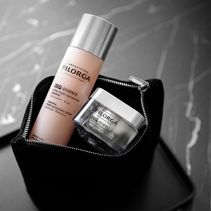 Filorga NCEF-Essence 150 ml heleyttävä hoitoneste ja kasvovoide mustassa meikkipussissa.