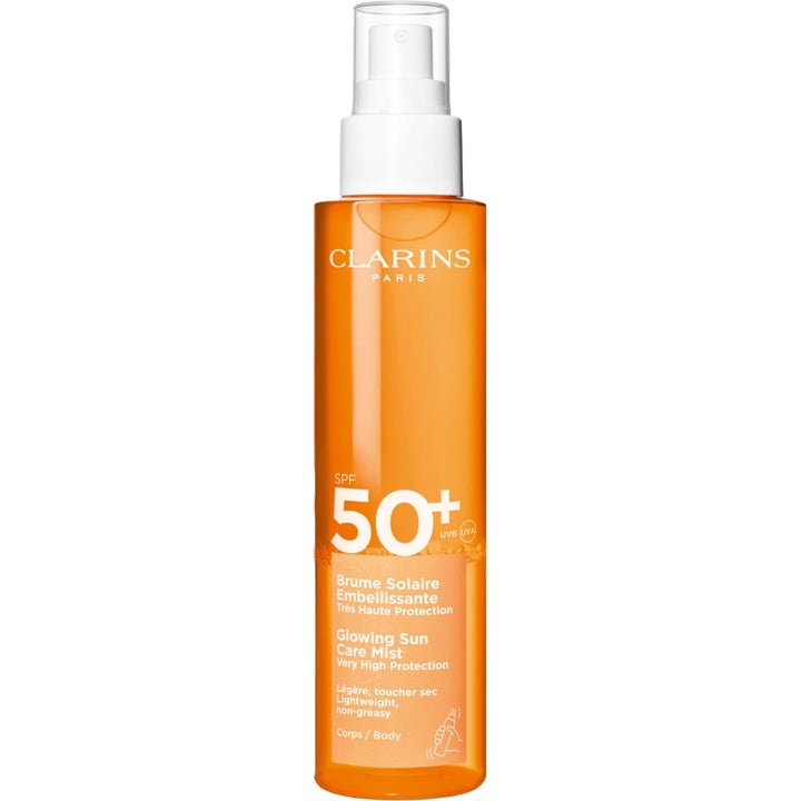 Clarins Glowing Sun Care Mist 150 ml SPF 50+ suojaava aurinkosuojasuihke läpinäkyvässä oranssissa muovipullossa.