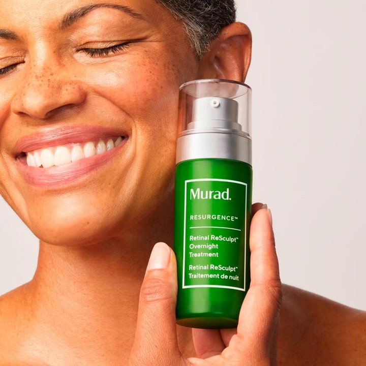 Murad Retinal ReSculpt Treatment 30 ml kiinteyttävä yöseerumi vihreässä pumppupullossa hymyilevän naisen pitelemänä